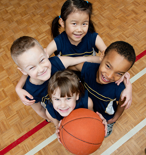 A diverse group of children on a basketball team.